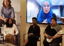 Conference attendees watching a woman speak to them through a television screen