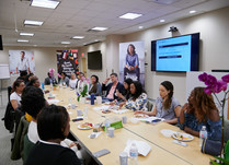 Conference attendees speaking to each other while sitting around a long table