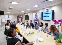Conference attendees speaking to each other while sitting around a long table