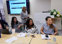 Three women engaged in conversation around a table