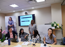 Woman presenting to conference attendees sitting around a long table