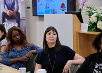 Conference attendees engaged in conversation around a table
