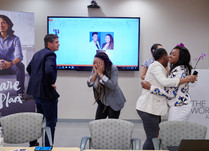 Conference attendees hugging & showing expressions of joy