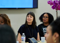 Conference attendees engaged in conversation around a table