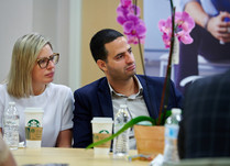 Conference attendees engaged in conversation around a table