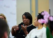 Conference attendees engaged in conversation around a table
