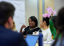 Conference attendees engaged in conversation around a table