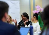 Conference attendees engaged in conversation around a table