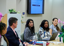 Conference attendees engaged in conversation around a table