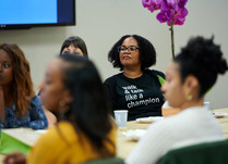 Conference attendees engaged in conversation around a table
