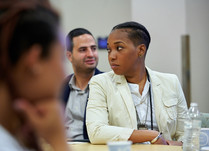 Conference attendees engaged in conversation around a table