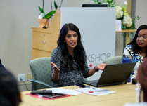 A woman with a laptop talking with other conference attendees