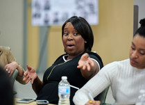Conference attendee gestures to something down the table while speaking