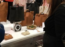 Woman looking at brown and black bags on a table
