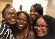 Four women gather together for a smiling selfie