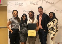 Mila Christina holding a certificate of completion posing for a group photo