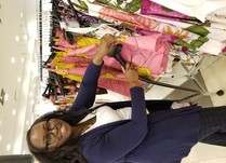 Woman steam cleaning clothes on a clothing rack