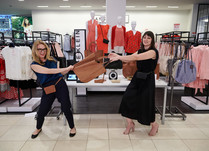 Two women pretend to be fighting over a bag
