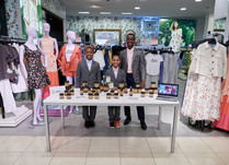 A man and two young boys proudly standing behind a product table