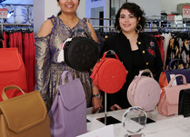 Two women proudly standing behind Gunas New York product table