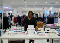 Woman proudly standing behind the foot nanny product table