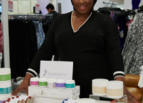 Woman proudly standing behind Foot nany product table
