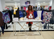 Woman proudly standing behind a product table