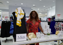 Woman proudly standing behind a product table