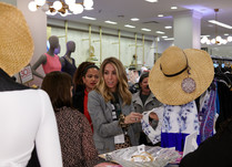 Woman looking at a clothing rack and talking with another woman