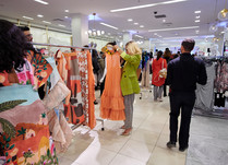 Woman looking at tangerine colored summer dress