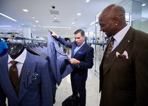 Two men looking at and discussing suits