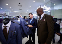 Two men looking at and discussing suits