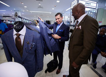 Two men looking at and discussing suits