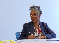 Woman sitting at a table with a pen in hand