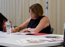 Woman sitting at a table taking notes