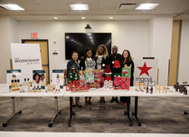 Workshop attendees standing behind a table with products and Christmas decorations