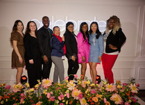 Group of 8 people standing in front of a celebrate sign