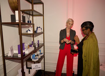 Two women talking by a shelf with products