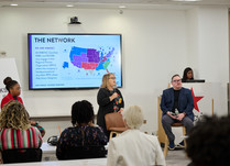 A seated panel of three presents to workshop attendees
