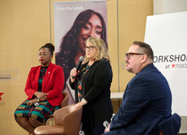A seated panel of three addresses attendee's question