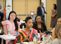 A female attendee with a microphone addresses the other workshop attendees