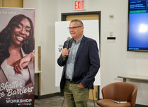 Man with a microphone addresses workshop attendees