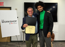 A man presenting a man with a Curl Daddy Certificate of Completion