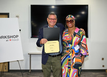 A man presenting a woman with a Dai Moda Certificate of Completion