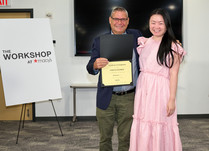 A man presenting a woman with an Emilia George Certificate of Completion