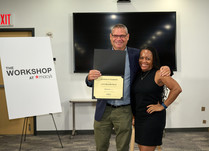 A man presenting a woman with a Lux Pillow Plus Certificate of Completion