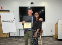 A man presenting a woman with a Certificate of Completion