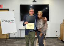 A man presenting a woman with a Sabila Skincare Certificate of Completion