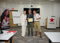 A man presenting two people with a Certificate of Completion