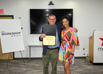 A man presenting a woman with a Certificate of Completion